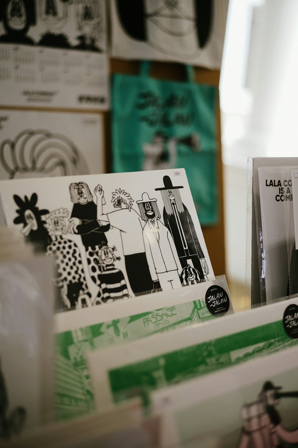 Black and white cartoon art prints displayed on a shelf.